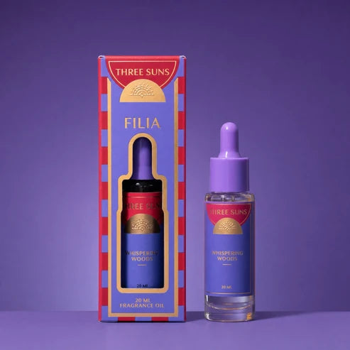 A bottle &amp; box of Three Suns Filia fragrance oil on a purple background