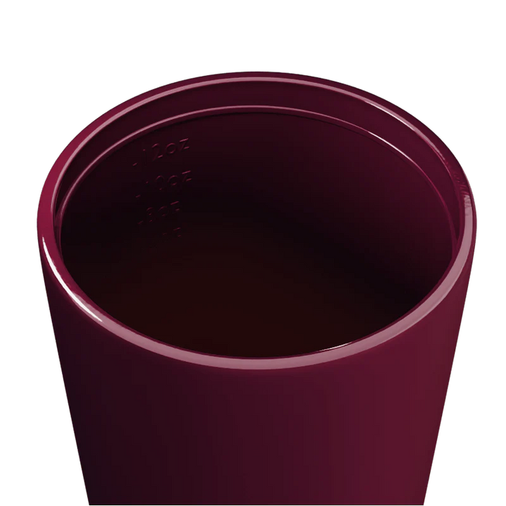 Inside of a Maroon travel cup on a white background