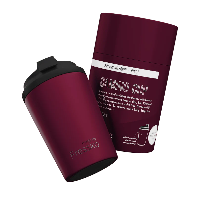 Maroon travel mug with black lid and packaging on a white background