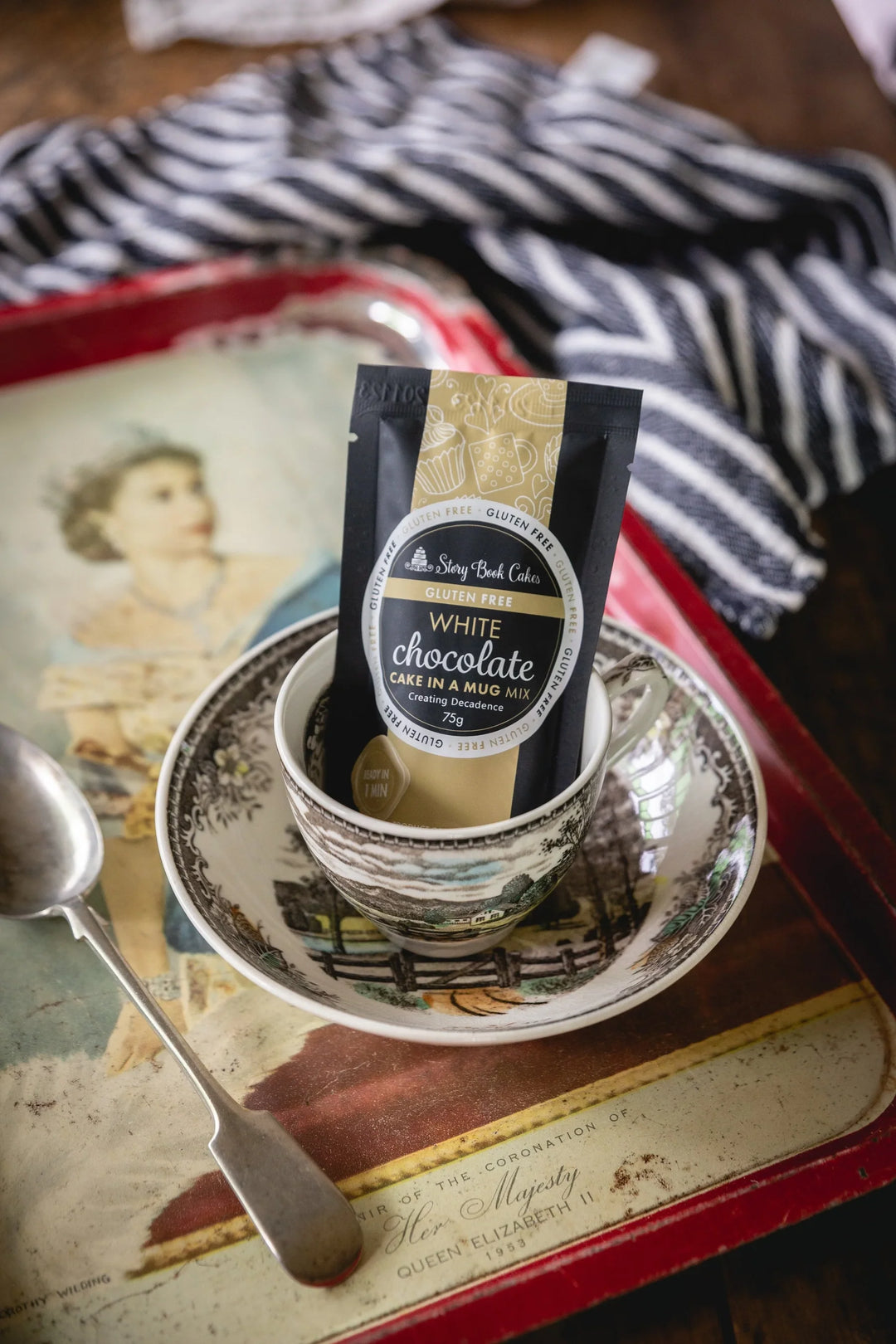 White chocolate cake mix package on a saucer with a spoon on a vintage tray