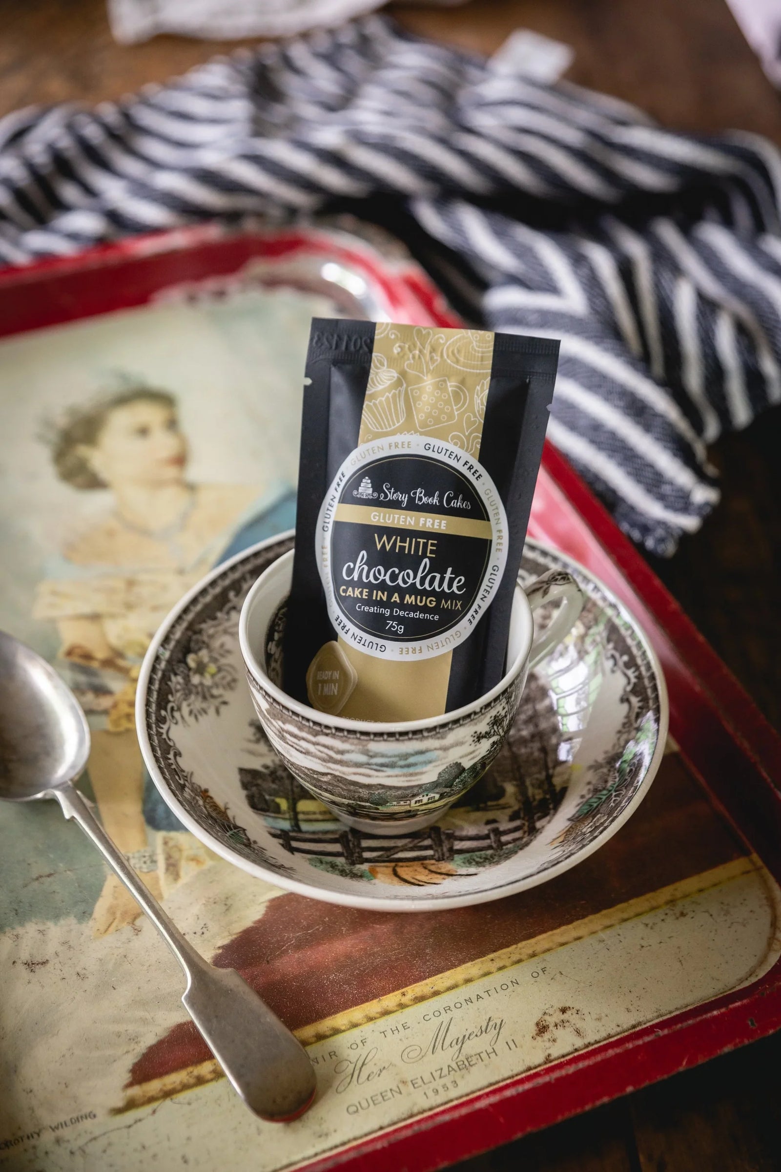 White chocolate cake mix package on a saucer with a spoon on a vintage tray