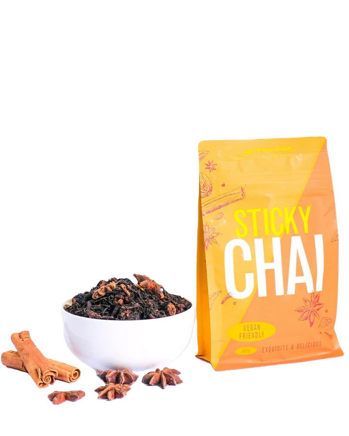 Sticky Chai spice mix with a bowl of spices and cinnamon sticks on a white background