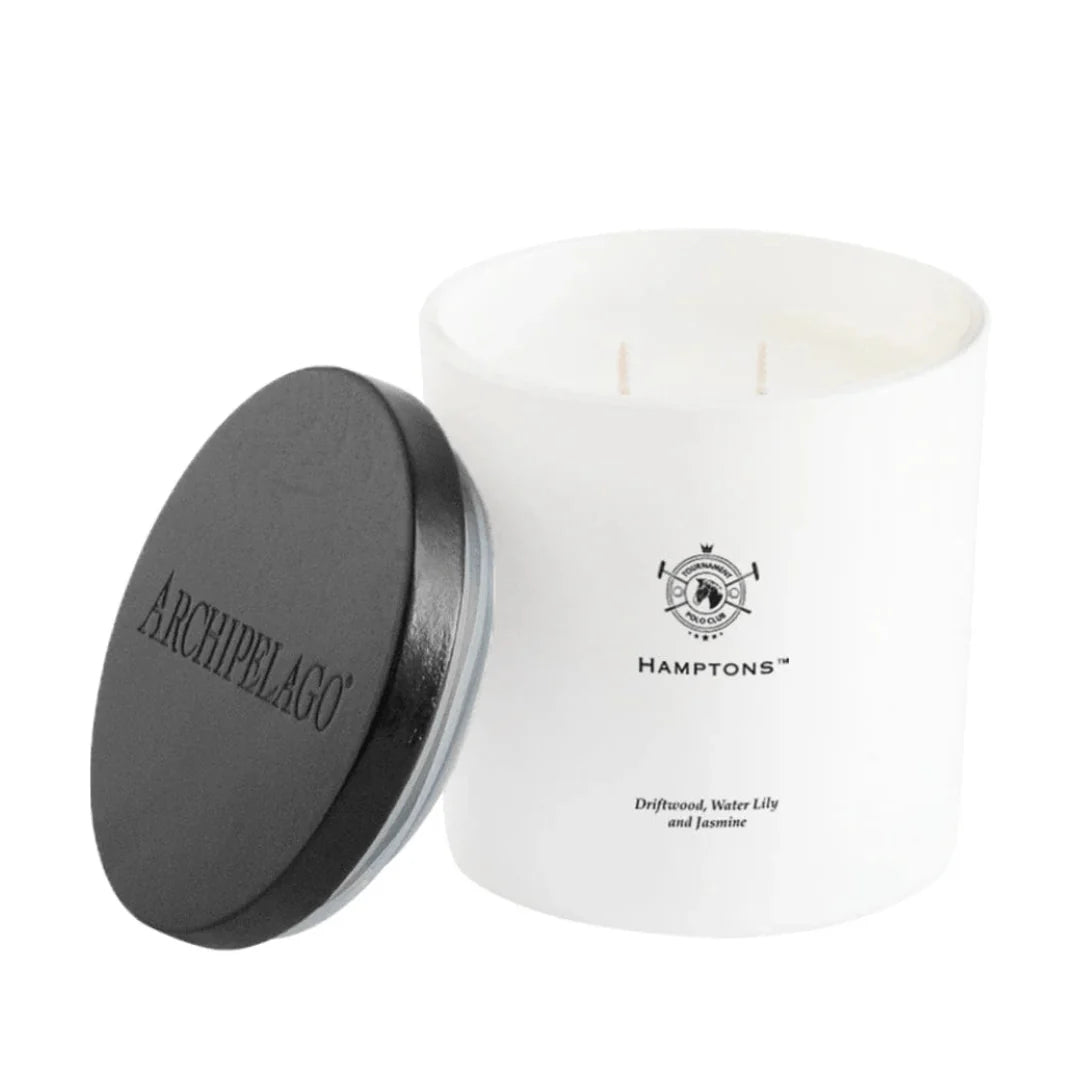 White candle with black lid featuring Archipelago branding on a white background
