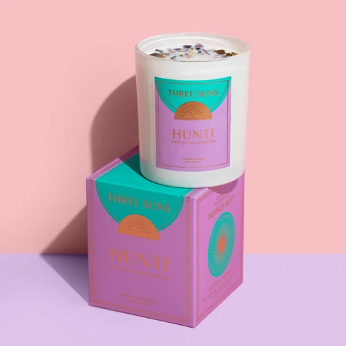 Three Suns Hunti Candle on a box on a pink background