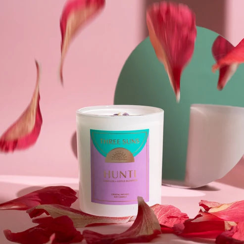 Candle with a label on a pink background with red petals