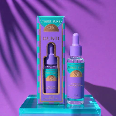 A box & bottle of Three Suns Hunti fragrance oil refill on a purple background
