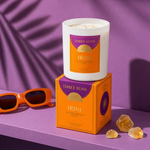 A Three Suns Irini candle and box on a purple shelf
