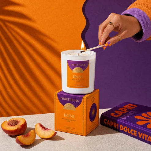 A hand lighting a Irini Candle with a match