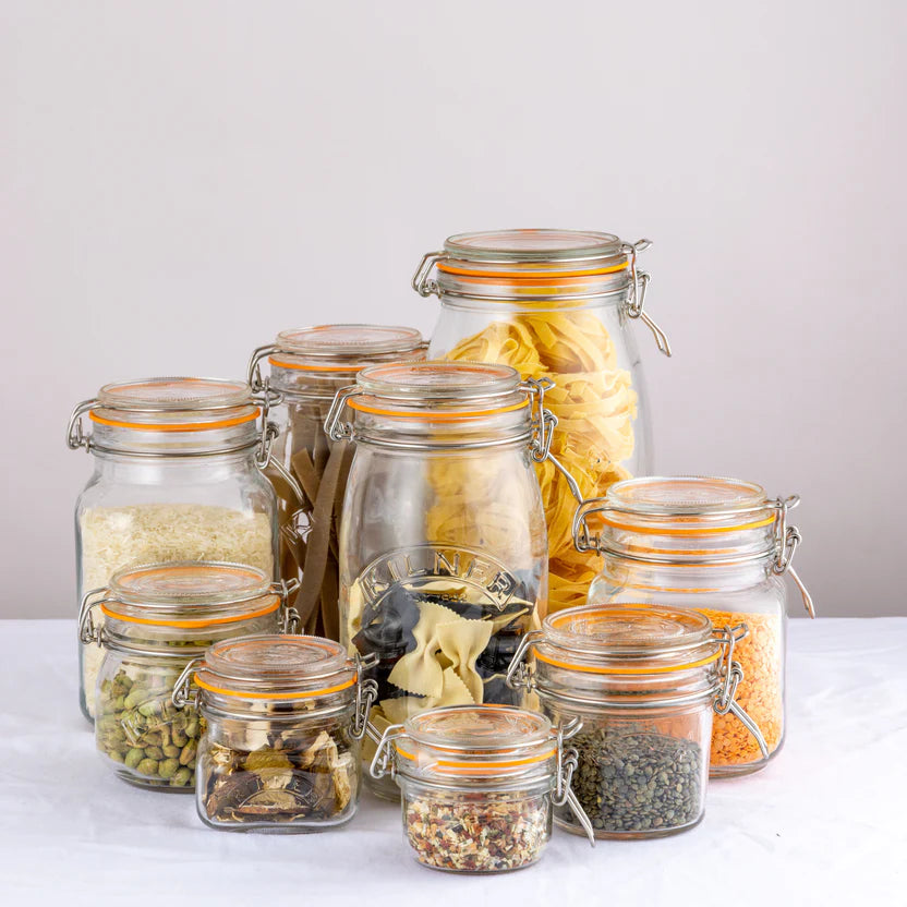 Collection of glass jars with various contents on a light background