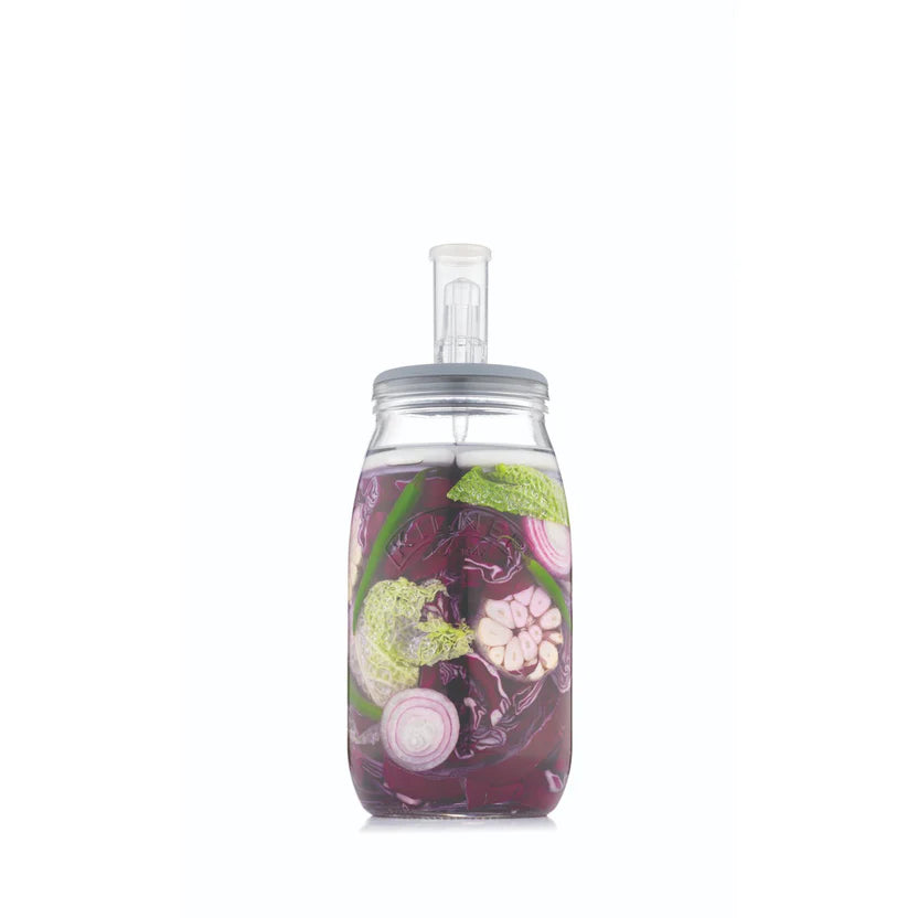 Fermenting jar full of colorful vegetables on a white background