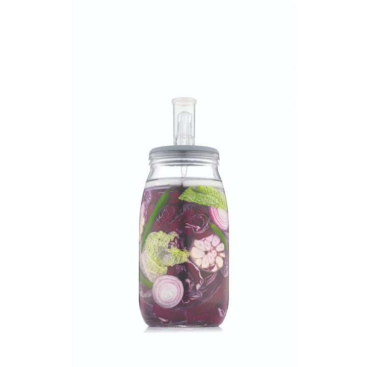 Fermenting jar full of colorful vegetables on a white background