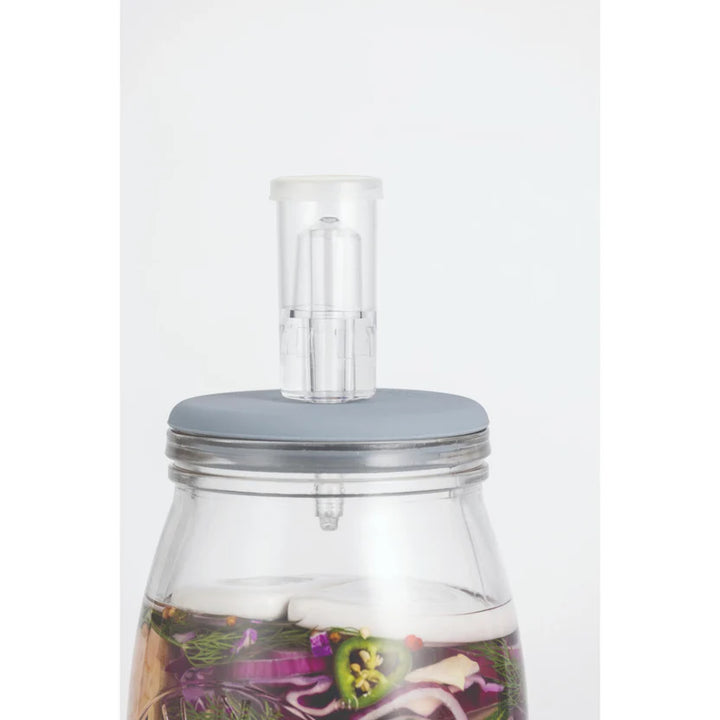 Clear fermenting jar with a grey lid and clear airlock on a white background