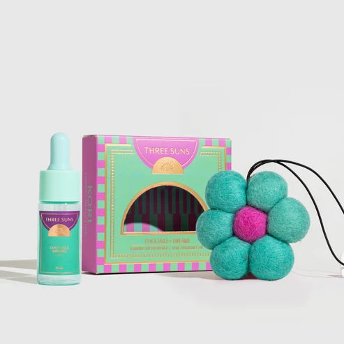 Three Suns air freshener with packaging and a decorative flower on a white background