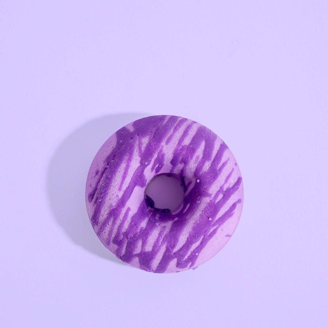 Purple and white marbled donut-shaped bath bomb on a light purple background