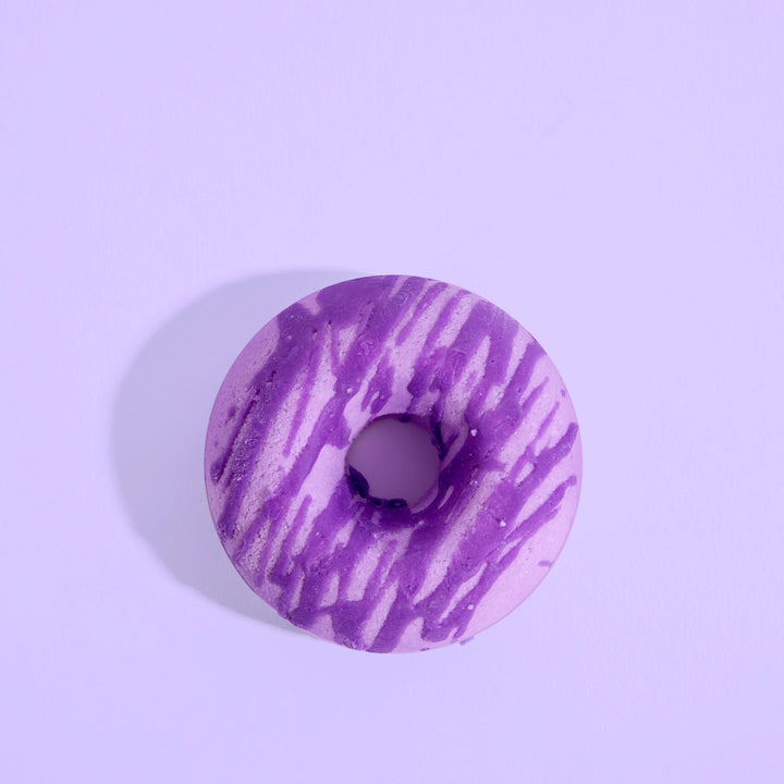 Purple and white marbled donut-shaped bath bomb on a light purple background