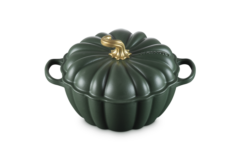 A dark green cast-iron Dutch oven shaped like a pumpkin, featuring a ribbed lid with a metallic gold faux-stem on top and two side handles, shown on a plain white background.