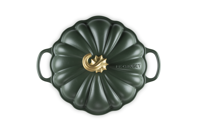 A Le Creuset enameled cast iron Dutch oven with a pumpkin-shaped lid, featuring a dark forest green finish and a gold-toned central logo accent.