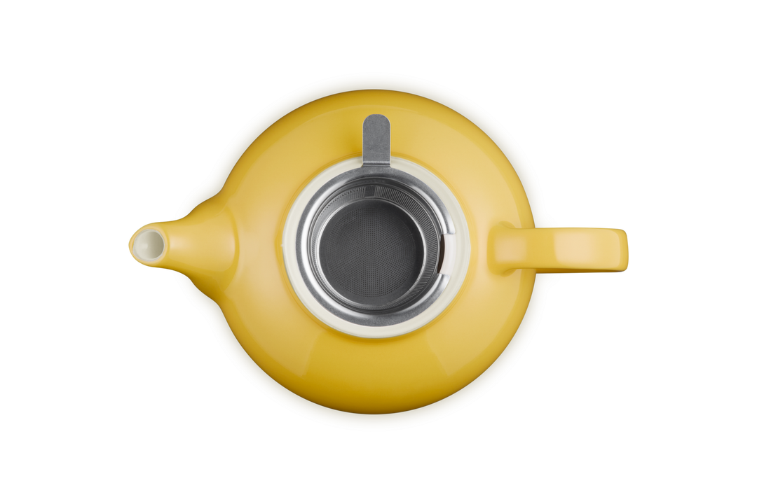 Yellow teapot with a clear glass lid on a white background