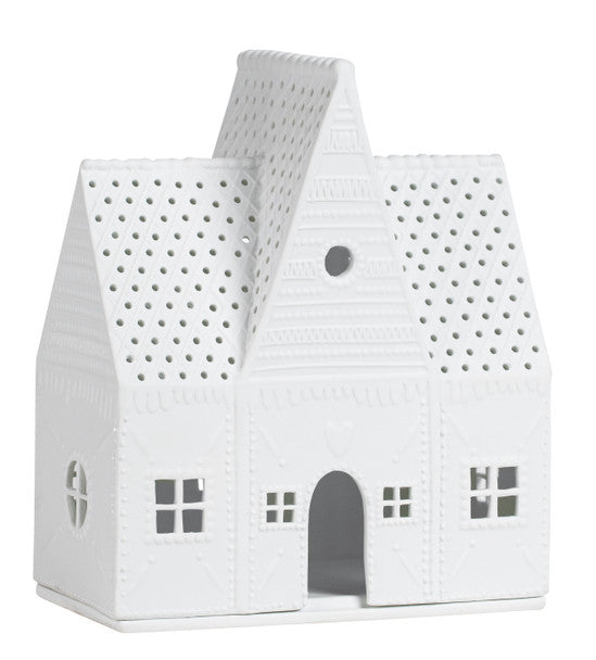 White gingerbread house-shaped tea candle holder with perforated design on a white background