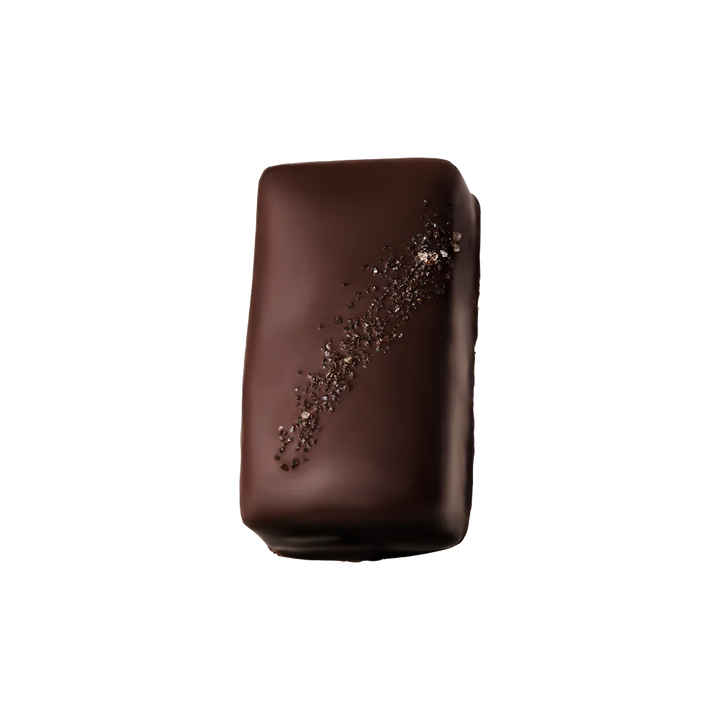 A single chocolate-covered rectangular chocolate bar with a glossy dark brown finish and a diagonal sprinkle of coarse chocolate flakes, isolated on a solid black background.
