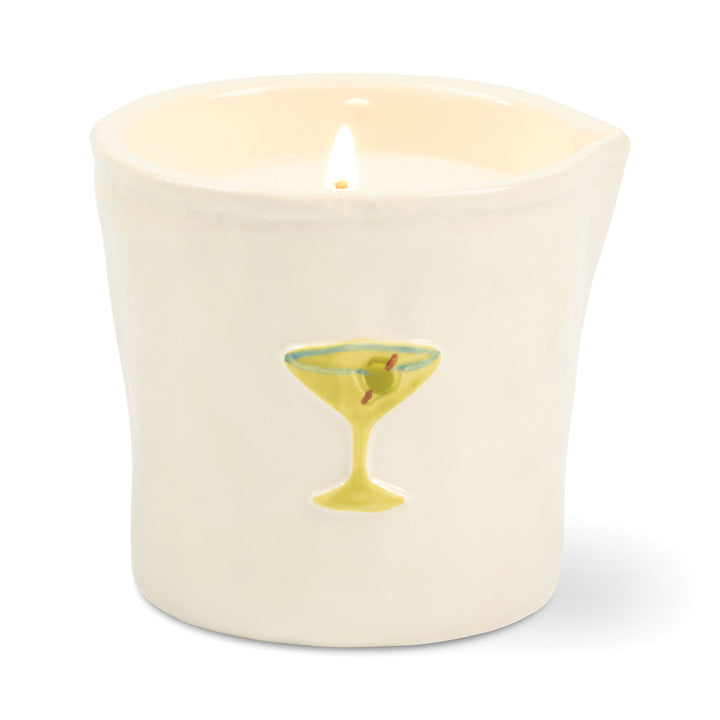 Candle in a white ceramic container with a design of a cocktail glass on a white background
