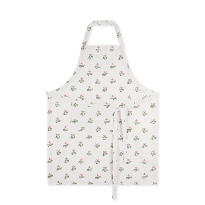 Cream coloured cotton apron with repeated mistletoe print on a white background