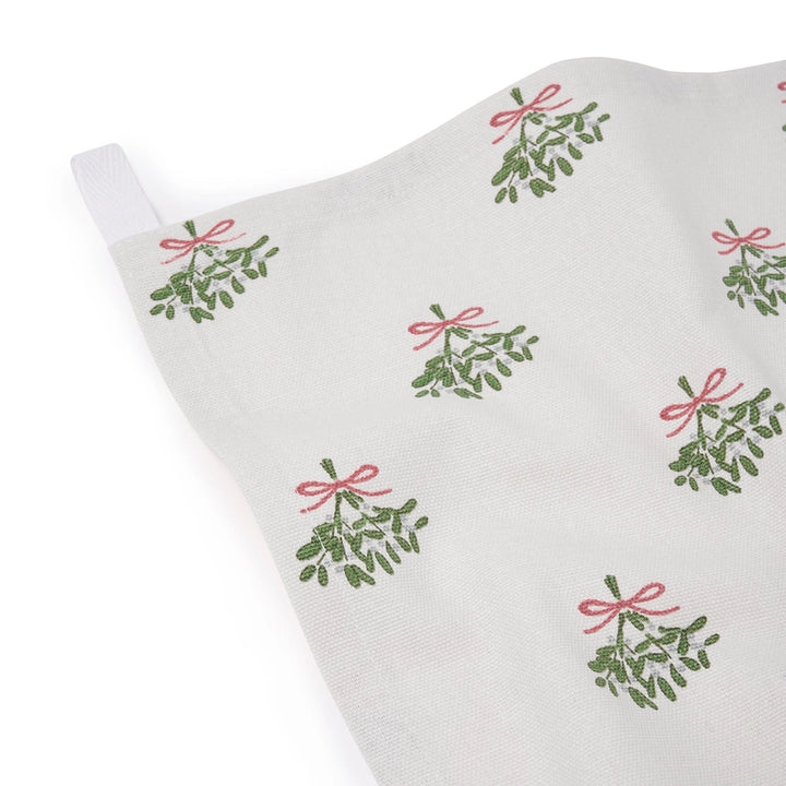 White tea towel with repeated mistletoe pattern on a white background