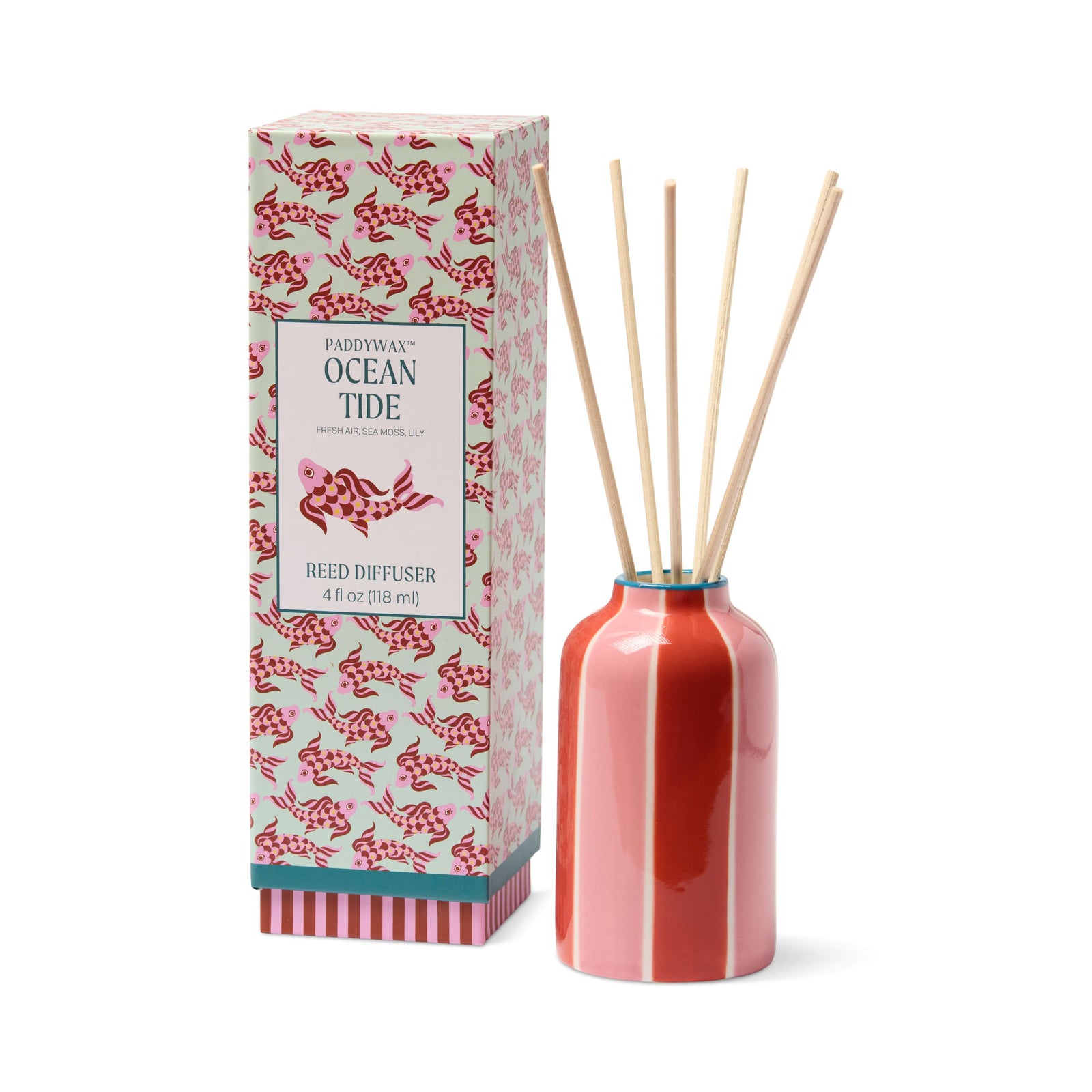 Paddywax Ocean Tide reed diffuser set with a glossy coral pink bottle, natural wooden reeds, and its patterned retail box on a white background.