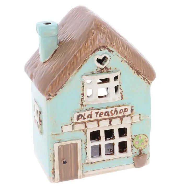 A ceramic tealight holder in the shape of a house with the words Old Teashop on it, on a white background