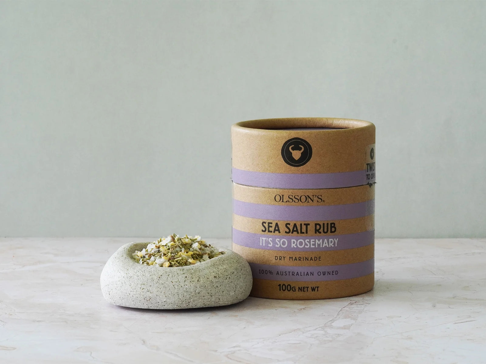 Sea salt rub container with a small dish of salt on a light surface