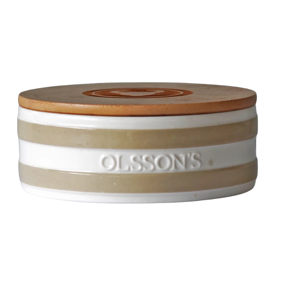 A stoneware salt keeper with beige and white stripes and wooden lid