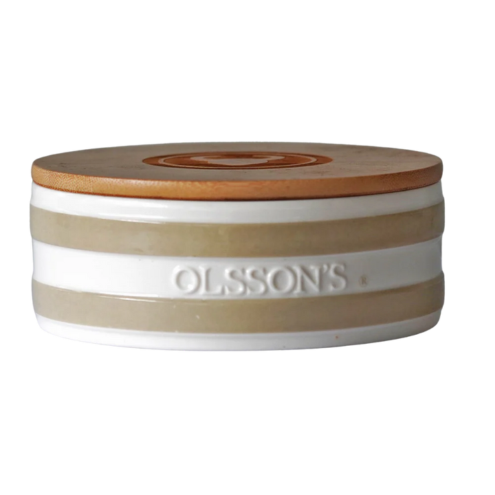 A stoneware salt keeper with beige and white stripes and wooden lid