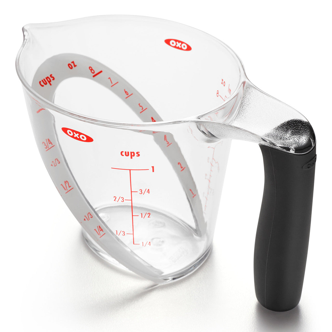 Clear measuring cup with black handle and red measurement markings on a white background