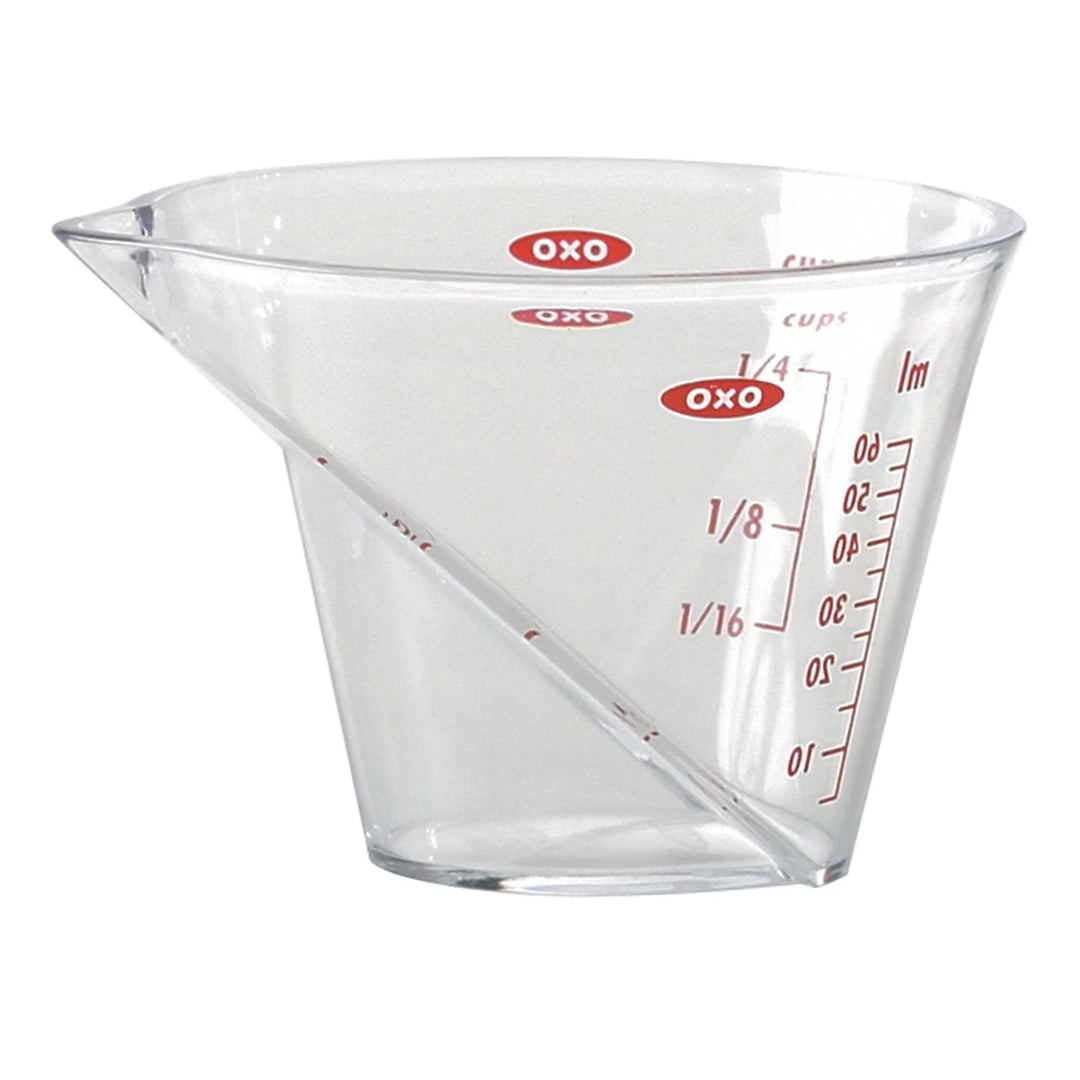 Clear measuring cup with red measurement markings on a white background