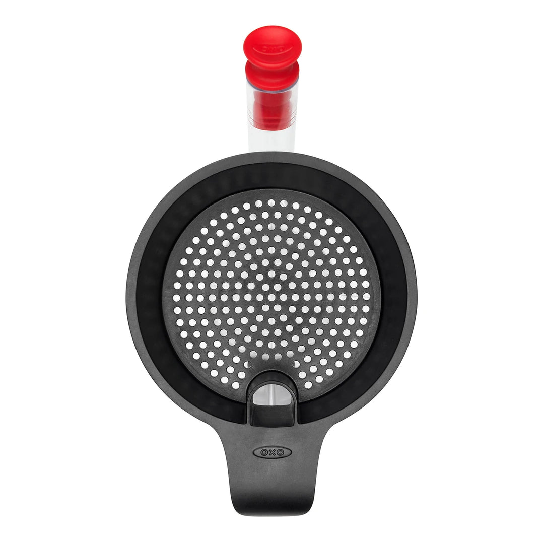 Black kitchen tool with red cap on a white background