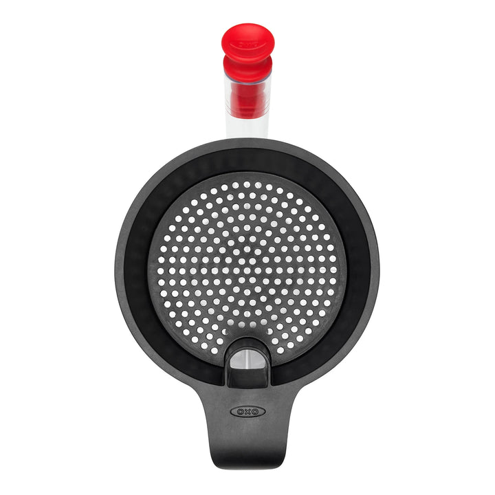 Black kitchen tool with red cap on a white background