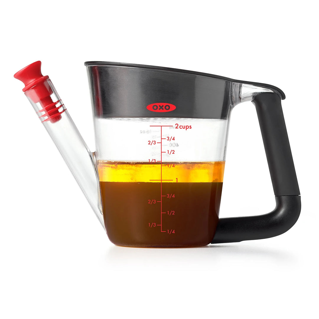 OXO measuring cup with liquid on a white background