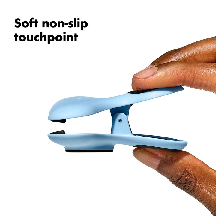 Blue clip with soft non-slip touchpoint held by a hand on a white background