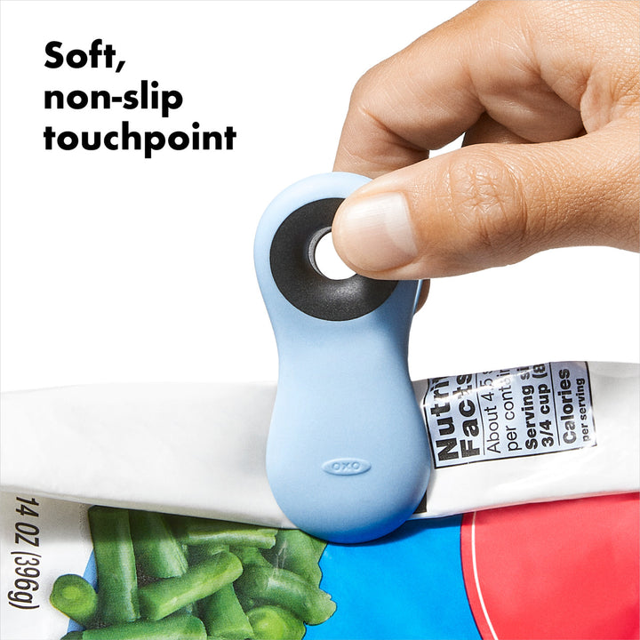 Blue tool with soft, non-slip touchpoint being used on a product packaging.