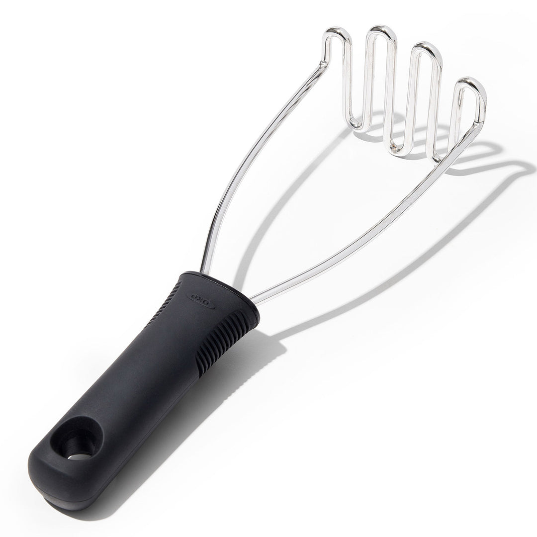 Black handled potato masher on a white background