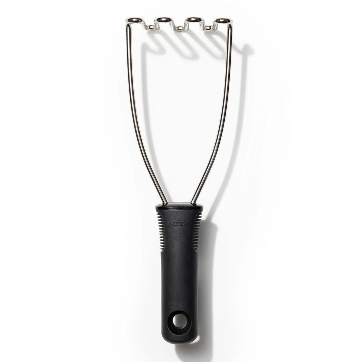 Black handled potato masher on a white background