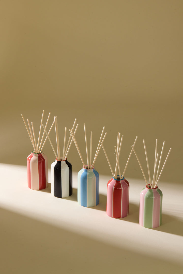 group of various coloured reed diffusers on neutral background