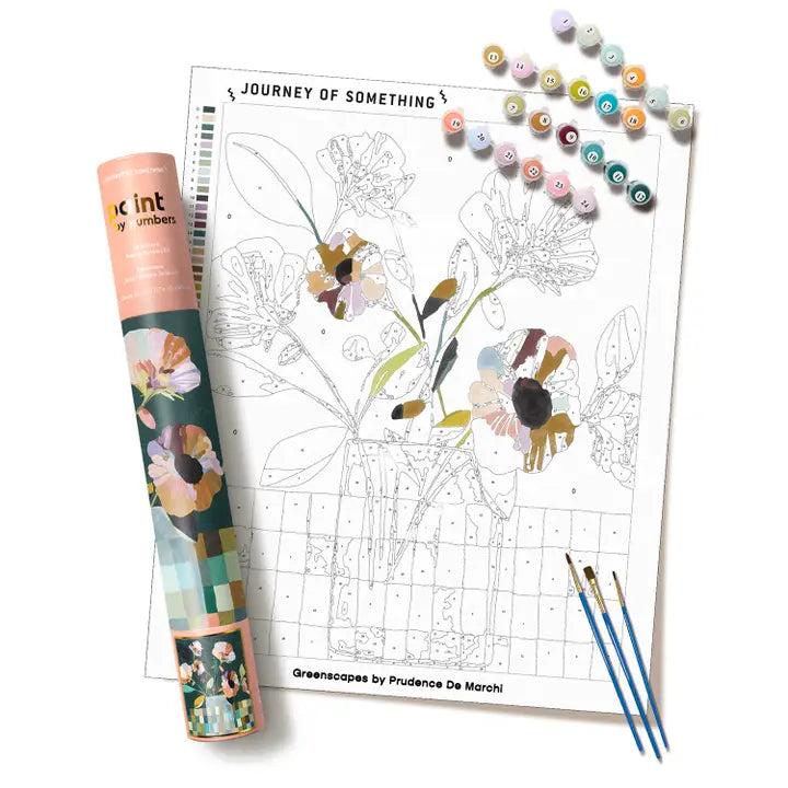A floral paint by numbers kit with a partially colored flower page, a rolled printed cover, numbered paint chips, and three paintbrushes on a clean white background. The visible text includes &