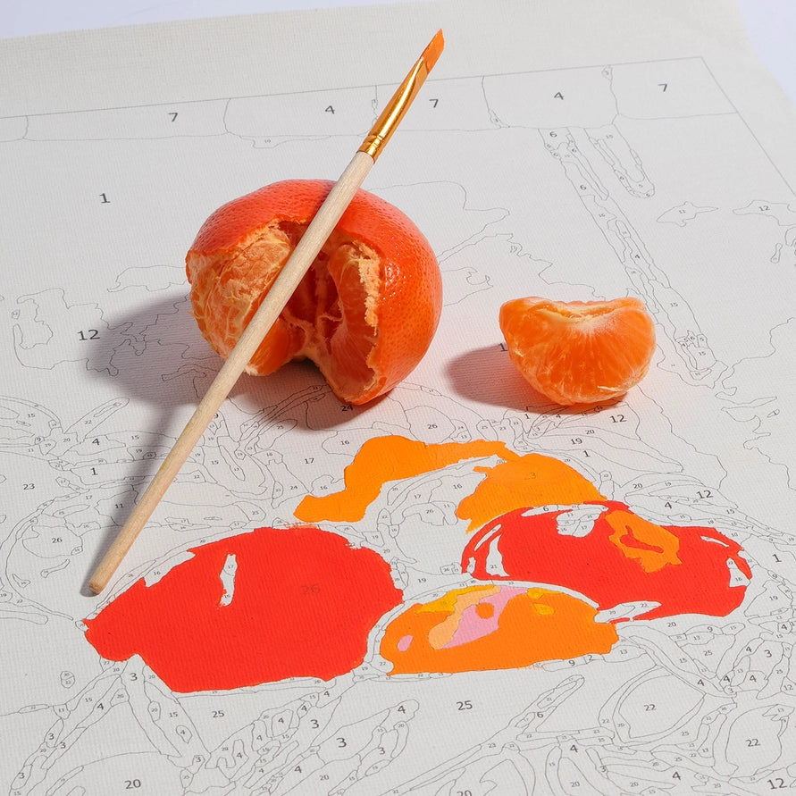 Orange with a paintbrush and painted orange shapes on a paper with measurements