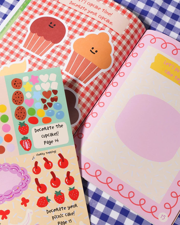 Colorful sticker sheets with cupcake and strawberry designs on a checkered fabric background.