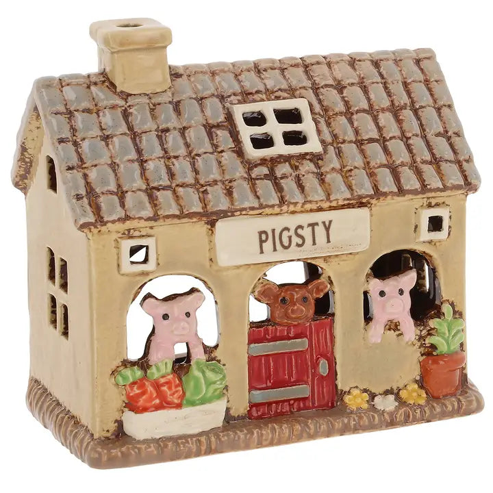 A ceramic pig pen tealight holder on a white background