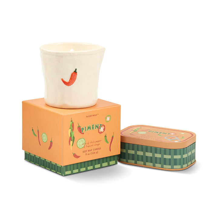 Candle with packaging and tin on a white background