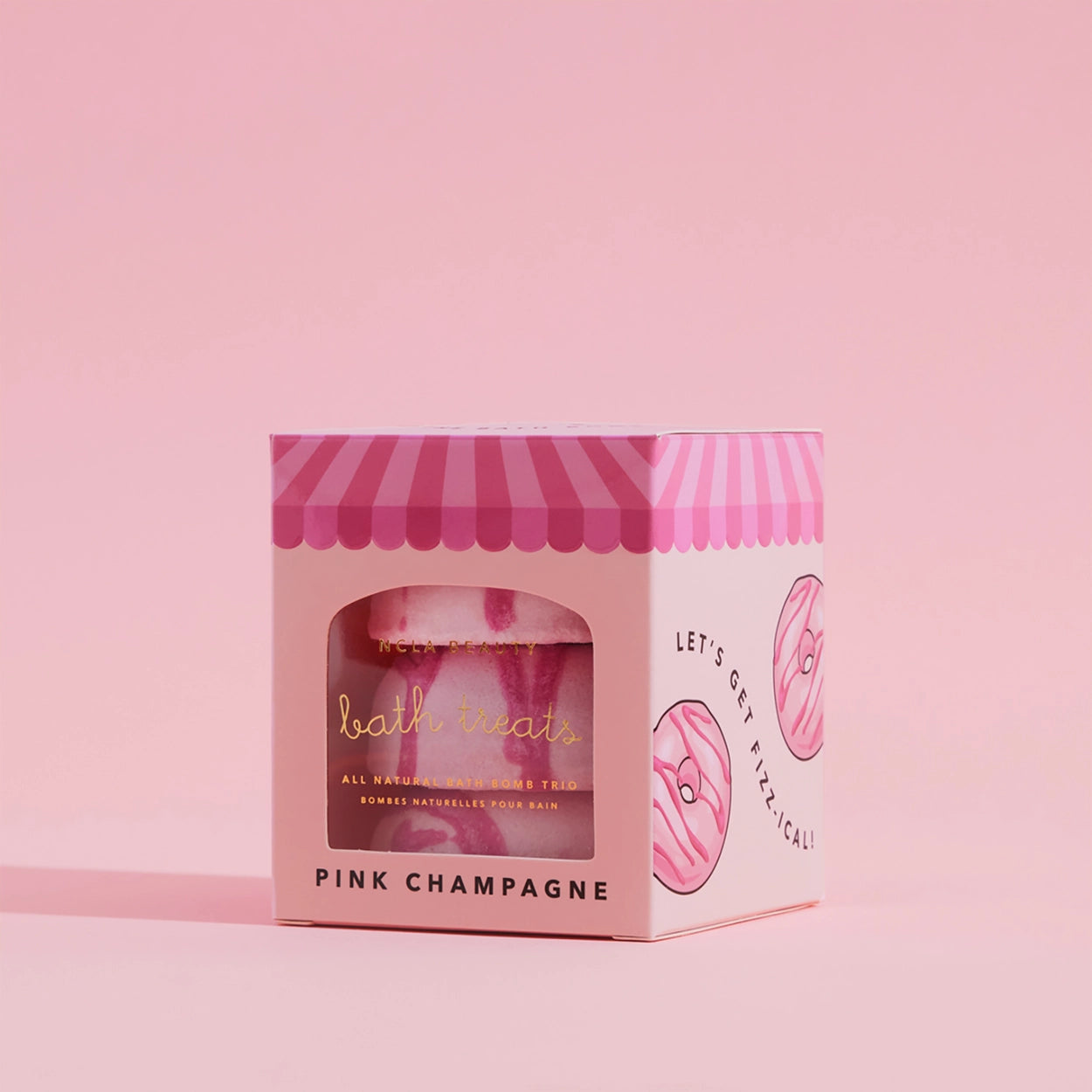 Pink packaging of a bath bomb with a striped lid on a pink background