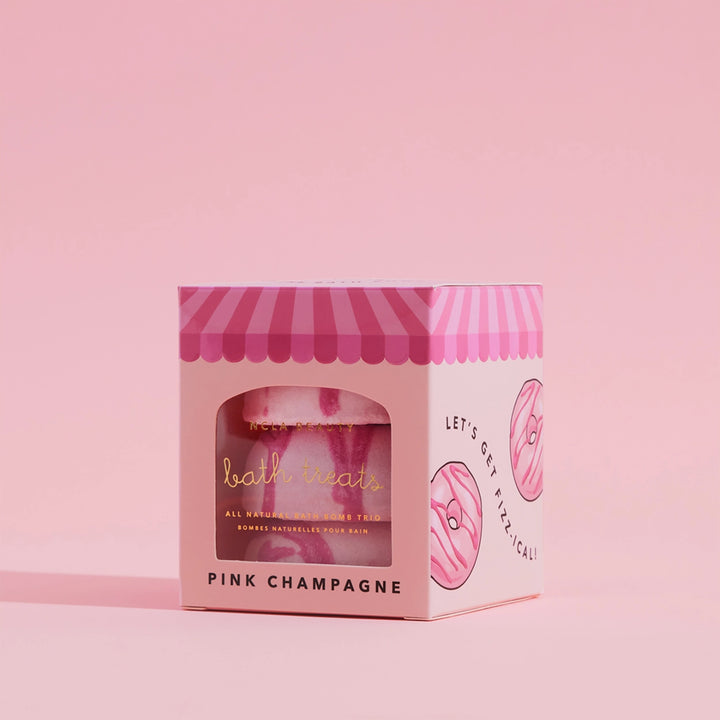 Pink packaging of a bath bomb with a striped lid on a pink background
