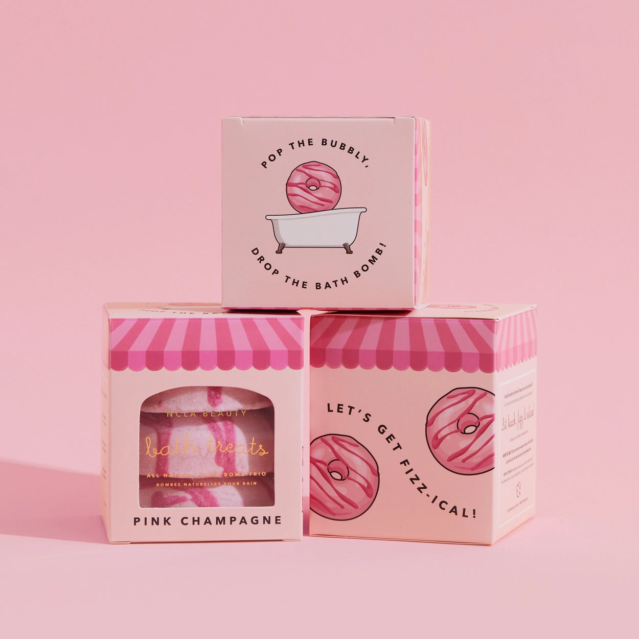 Three pink bath bomb boxes with decorative designs and text on a pink background